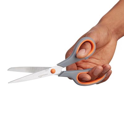 AmazonBasics Office scissors · pair: A hand holds one scissors from the pair; not a measured scale.